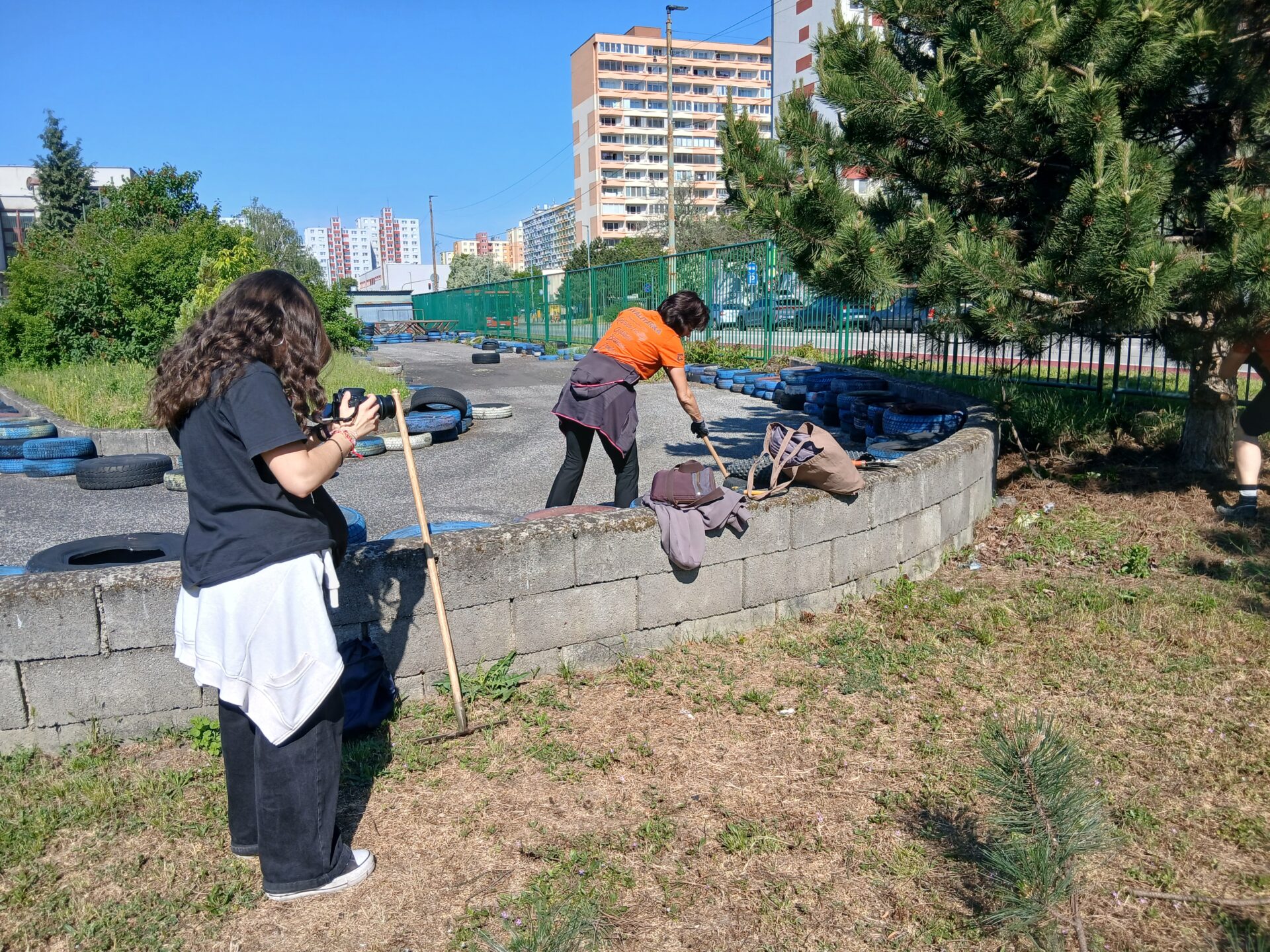 Paula holding a camera and taking pictures of volunteers helping.